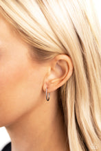 Load image into Gallery viewer, A skinny bar of silver drops from the ear, creating a dainty, elongated hoop in the shape of a &quot;J&quot;. Earring attaches to a standard post fitting. Hoop measures approximately 3/8&quot; in diameter. 
