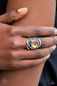 A pair of sleek silver bands — one dotted in hematite rhinestones — orbit around a radiant-cut, oil spill gem, for an edgy, three-dimensional centerpiece atop the finger. Features a stretchy band for a flexible fit. Due to its prismatic palette, color may vary.  Sold as one individual ring.  New Kit Fashion Fix