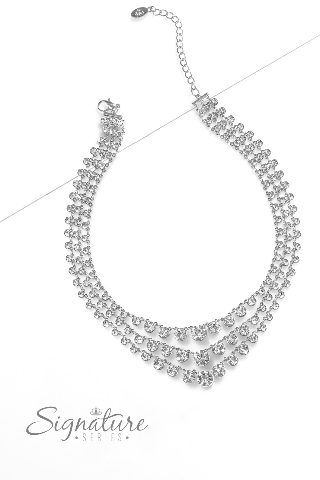 Rows of glittery, white rhinestones drape between two sleek silver bars, falling into three luxurious layers. The sparkling gems gradually increase in size as they fall toward the center of the design, adding dazzling dimension to the twinkling tiers. Features an adjustable clasp closure.  Sold as one individual necklace. Includes one pair of matching earrings.
