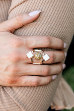 Load image into Gallery viewer, A marbled blue stone is wrapped in a dainty border of textured gold, as it sits between two arcing gold bands atop the finger. Two white shells — each tilted on point — lay above and below the polished blue stone, resulting in an elongated stack of earthy elegance. Features a stretchy band for a flexible fit. As the stone elements in this piece are natural, some color variation is normal.  Sold as one individual ring.
