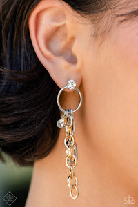 A strand of oversized silver chain links slides along the bottom of a simple silver hoop, colliding with a solitaire rhinestone and a cascade of shimmery gold chain. A classic white rhinestone sits atop the silver hoop, anchoring the industrial mashup to a glitzy foundation. Earring attaches to a standard post fitting.  Sold as one pair of post earrings.