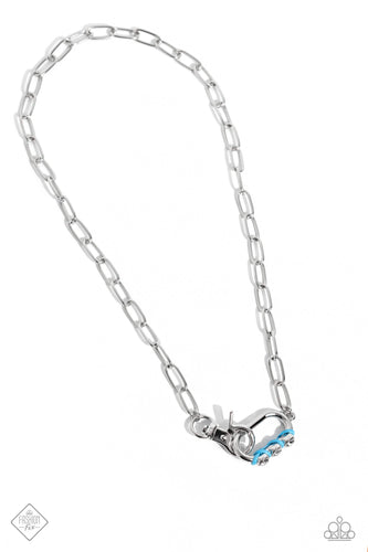 Sleek, elongated silver links lead the eye down to an oversized silver carabiner frame. Encrusted along the bottom curve of the silver hardware, a trio of gems, woven across blue cording, glimmers for a subtle pop of color down the neckline. Features a clasp closure.  Sold as one individual necklace. Includes one pair of matching earri