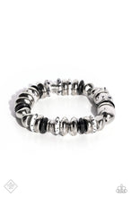 Load image into Gallery viewer, Featuring a black-dotted pattern, abstract white stone discs, black acrylic discs, and various silver discs and accents are threaded along an elastic stretchy band for a high-end, artisanal-inspired look. As the stone elements in this piece are natural, some color variation is normal.
