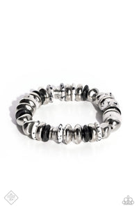Featuring a black-dotted pattern, abstract white stone discs, black acrylic discs, and various silver discs and accents are threaded along an elastic stretchy band for a high-end, artisanal-inspired look. As the stone elements in this piece are natural, some color variation is normal.