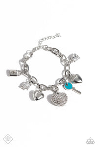 An assortment of charms, including silver hearts, pronged white gems, a turquoise-painted key and silver lock, and rhinestone-embellished thick heart dangle from a silver paperclip chain for a carefree finish around the wrist. Features an adjustable clasp closure.