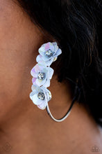 Load image into Gallery viewer, A trio of white flowers, featuring an iridescent sheen and dotted with white pronged rhinestone centers, blossoms atop a thin silver hoop for a dreamy, whimsical finish. Earring attaches to a standard post fitting. Hoop measures approximately 2 1/2&quot; in diameter. Due to its prismatic palette, color may vary.  Sold as one pair of hoop earrings.
