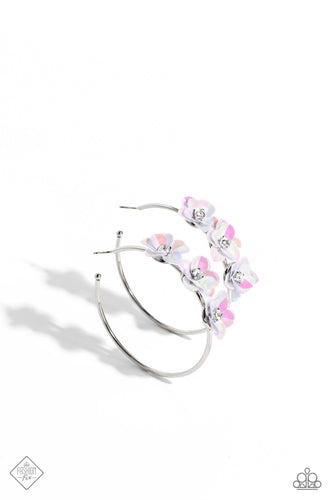 A trio of white flowers, featuring an iridescent sheen and dotted with white pronged rhinestone centers, blossoms atop a thin silver hoop for a dreamy, whimsical finish. Earring attaches to a standard post fitting. Hoop measures approximately 2 1/2