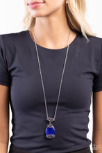 Load image into Gallery viewer,  Infused with an elegantly elongated silver chain, a dramatic blue cat&#39;s eye teardrop, framed in a studded filigree frame, swings from the bottom of an iridescent and multicolored rhinestone-encrusted silver fitting, creating a hypnotic pendant. Features an adjustable clasp closure. Due to its prismatic palette, color may vary. 
