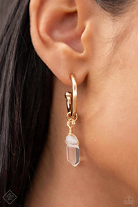 A small, skinny, gold hoop curves around the ear in a timeless fashion. A gold ball is affixed to the end of the hoop, reminiscent of a barbell fitting. Delicately attached to gold wire, a chiseled piece of clear white stone slides along the curvature of the hoop, adding a surprising hint of stony movement. Earring attaches to a standard post fitting. Hoop measures approximately 3/4" in diameter. As the stone elements in this piece are natural, some color variation is normal.