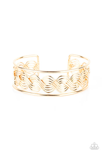 Flattened in sections, rows of glistening gold wire weave between two gold bars, creating a shimmery cuff around the wrist.