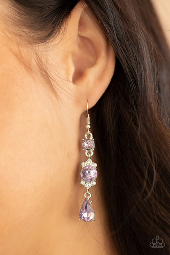 Featuring a white rhinestone encrusted frame, an oversized purple rhinestone is linked between a classic round and teardrop purple rhinestone for an elegantly stacked look. Earring attaches to a standard fishhook fitting.  Sold as one pair of earrings.