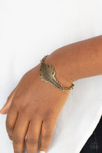 Load image into Gallery viewer, Etched and embossed in lifelike detail, a rustic brass feather centerpiece attaches to an antiqued brass chain around the wrist. Features an adjustable clasp closure.  Sold as one individual bracelet.
