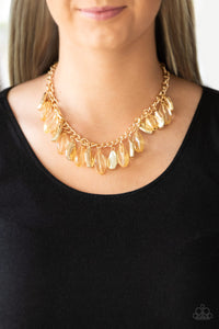 Faceted golden beads and imperfect gold teardrops drip from the bottom of a shimmery gold chain, creating a sassy fringe below the collar. Features an adjustable clasp closure.