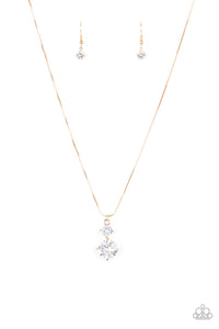 Nestled inside classic gold prongs, two oversized white rhinestones slide along a dainty gold snake chain, creating a dramatic pendant below the collar. Features an adjustable clasp closure.