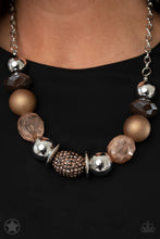 Load image into Gallery viewer, Warm beads in shades of brown and copper with reflective faceted edges and varying glazed finishes are offset by two shiny silver beads.  An oblong bead studded with copper-toned rhinestones adds a dramatic accent.  Features an adjustable clasp closure. 
