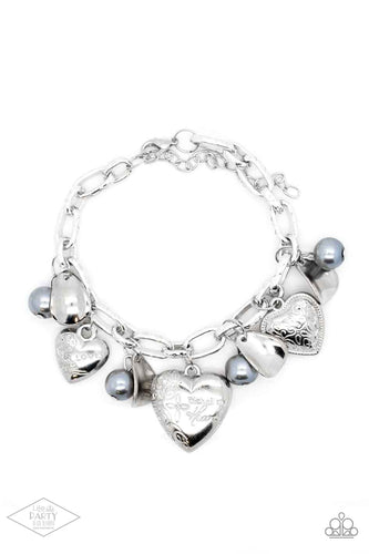 Oversized silver links are adorned with curved silver discs, pearly gray beads, and an assortment of heart charms.  One heart is etched with floral designs and the word, “Love,” another is swirled with filigree and bordered by textures, and the largest heart is inscribed with the phrase, “With all my heart” on one side and a short bible verse on the other that reads, 