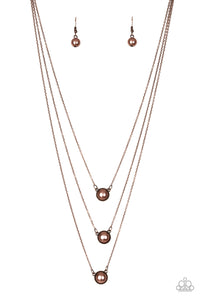 Three copper pearl drop pendants layer down the chest in a refined fashion. Features an adjustable clasp closure.