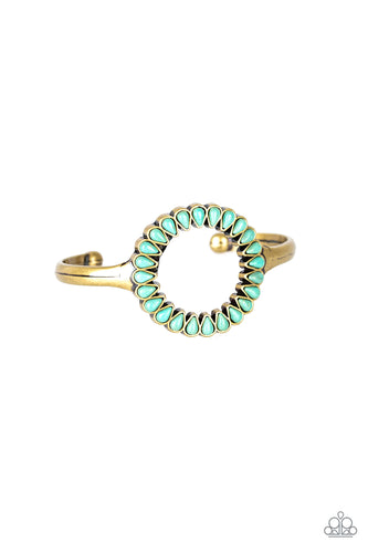 Chiseled into tranquil teardrops, refreshing turquoise stones spin around the center of an antiqued brass cuff for a seasonal look.