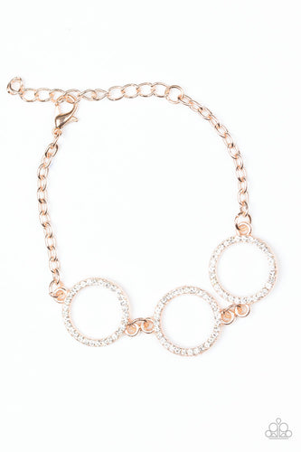 Encrusted in glassy white rhinestones, three glittery rose gold rings link across the wrist for a glamorous look. Features an adjustable clasp closure.