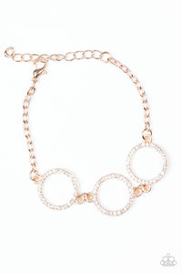 Encrusted in glassy white rhinestones, three glittery rose gold rings link across the wrist for a glamorous look. Features an adjustable clasp closure.
