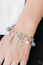 Load image into Gallery viewer, Pink pearls, ornate silver beads, and white rhinestone encrusted accents swing from a dramatic silver chain. A shimmery silver bird charm and silver tassel are added to the display, creating a whimsical fringe around the wrist. Features an adjustable clasp closure.
