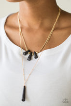 Load image into Gallery viewer, Chiseled into flared teardrop shapes, a dainty fringe of black stones and golden beads gives way to a large stone pendant, creating earthy layers down the chest. Features an adjustable clasp closure.
