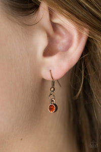 Encrusted in radiant rhinestones, three copper hoops interlock at the bottom of an elongated copper chain for an elegant look. Features an adjustable clasp closure.