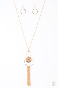 A delicately hammered gold disc is stamped in the inspirational word, "faith" and suspended from a double-hooped pendant at the bottom of an elongated gold satellite chain. A gold tassel swings from the bottom of the shimmery palette for a whimsical finish. Features an adjustable clasp closure.