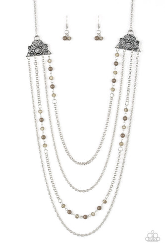 Attached to two ornate floral silver fittings, shimmery silver chains and strands of polished green and glassy crystal-like beads cascade across the chest for a whimsically layered look. Features an adjustable clasp closure.