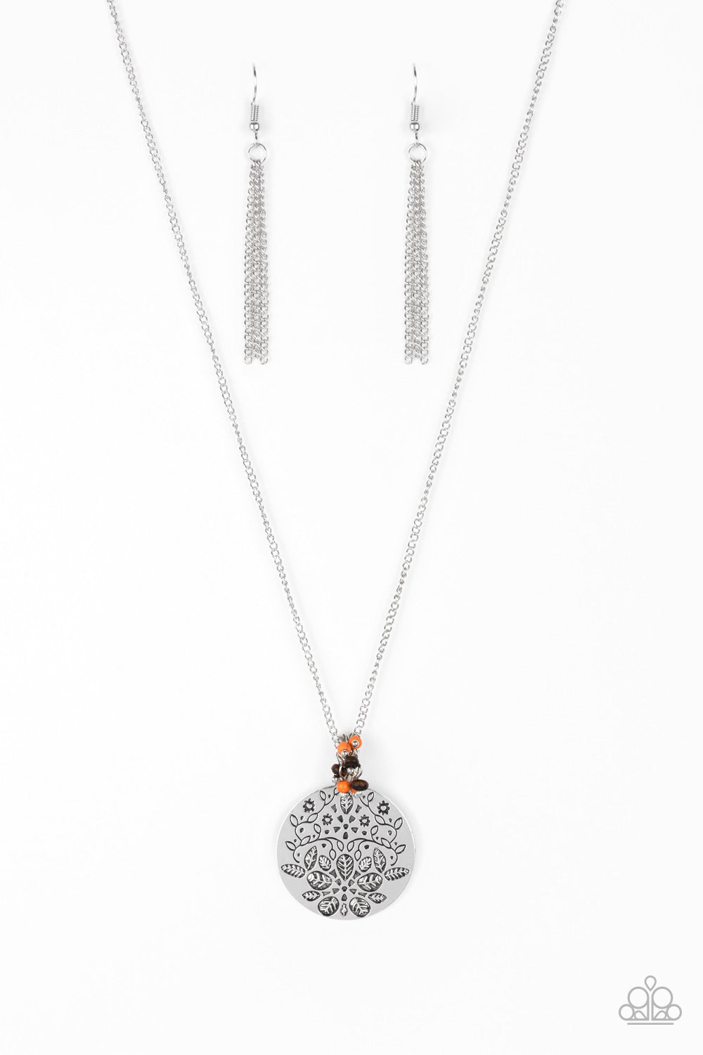 A floral embossed silver disc and dainty wooden and orange stone beads swing from the bottom of a lengthened silver chain for a whimsical look. Features an adjustable clasp closure.