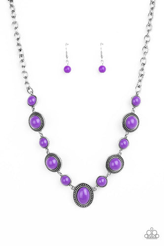 Featuring smooth and studded silver frames, vivacious purple beads link below the collar in a seasonal fashion. Features an adjustable clasp closure.