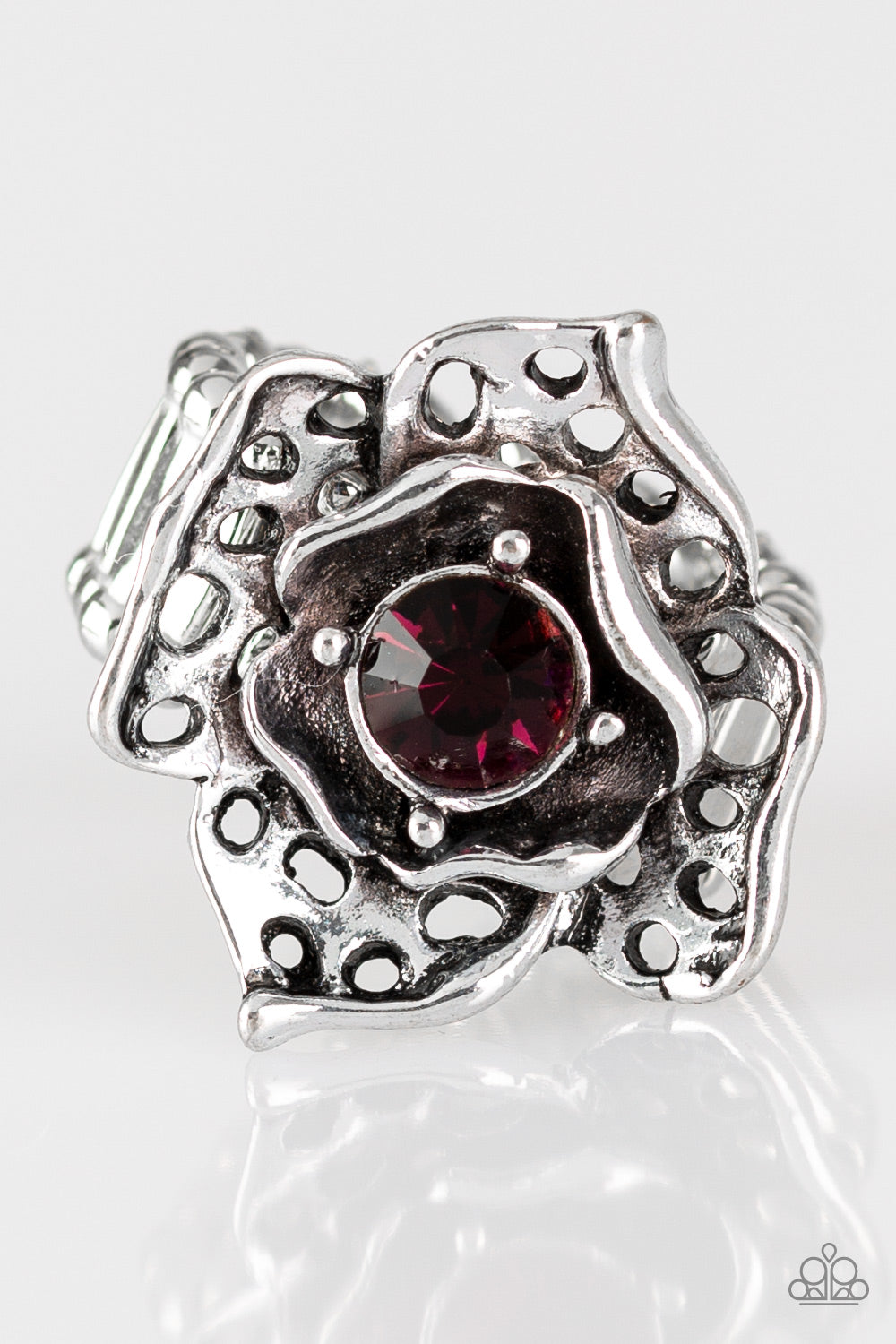 Featuring airy cut-out textures, antiqued silver petals gather around a glowing purple rhinestone center for a whimsical look. Features a stretchy band for a flexible fit