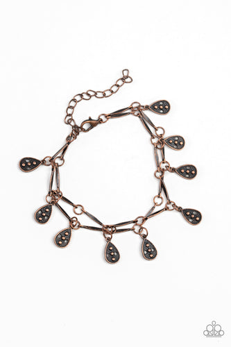Glistening copper rods and ornate teardrops link around the wrist in two rows, creating a playful fringe. Features an adjustable clasp closure.