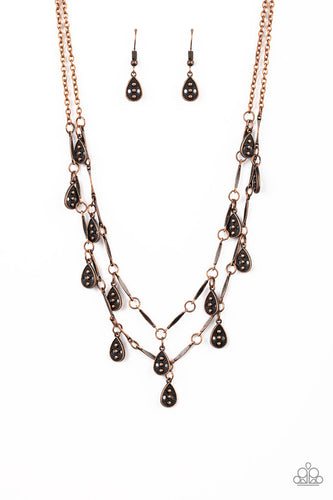 Glistening copper rods and ornate teardrops link below the collar in two rows, creating a playful fringe. Features an adjustable clasp closure.