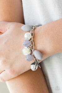 Gorgeous pearls, luminescent gray beading, and a collection of shiny silver charms, including a bird and a feather, dance around the wrist in a whimsical fashion. Features an adjustable clasp closure.