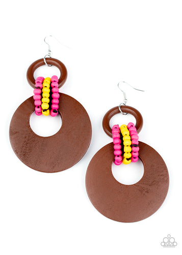 Pink and yellow wooden beaded links connect together a brown wooden ring and an oversized brown wooden crescent-like hoop, creating a vivaciously earthy lure. Earring attaches to a standard fishhook fitting.