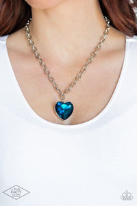 Set atop a sleek silver fitting, a glittery blue heart-shaped gem swings from the bottom of a classic silver chain below the collar for a whimsical look. Features an adjustable clasp closure.