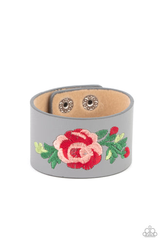 A leafy rose is embroidered across the center of a thick gray leather band, adding a hint of girly girl glam to the seasonal centerpiece. Features an adjustable snap closure.  Sold as one individual bracelet.