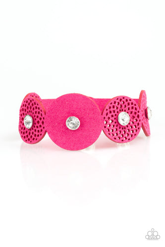 Dotted with white rhinestone centers, round pink suede frames join across the wrist for a whimsical look. Features an adjustable snap closure.