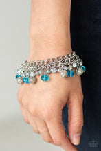 Load image into Gallery viewer, A collection of metallic net covered beads, shiny silver beads, and glittery blue and metallic flecked crystal-like beads swing from the wrist, creating a refined fringe. Features an adjustable clasp closure.
