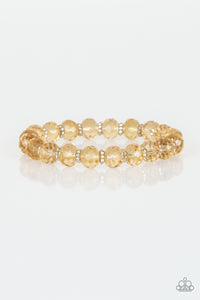 Glittery crystal-like beads and studded silver rings are threaded along a stretchy band around the wrist for a sophisticated look.