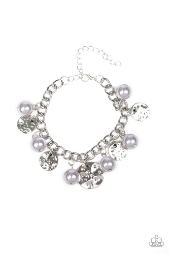 A collection of hammered silver discs and pearly silver beads swing from a thick silver chain, creating an elegant fringe around the wrist. Features an adjustable clasp closure. 