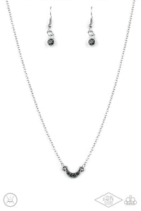 Encrusted in smoky rhinestones, a dainty silver half-moon frame attaches to a dainty shimmery chain around the neck for a minimalist inspired fashion. Features an adjustable clasp closure.