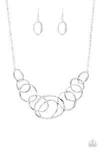 Featuring a subtle hammered finish, a collection of asymmetrical silver rings join into a stationary pendant below the collar for a bold look. Features an adjustable clasp closure