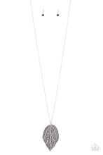 Load image into Gallery viewer, Featuring lifelike patterns, a hematite rhinestone encrusted silver leaf swings from the bottom of a lengthened silver chain, creating an edgy pendant. Features an adjustable clasp closure.
