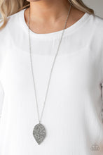Load image into Gallery viewer, Featuring lifelike patterns, a hematite rhinestone encrusted silver leaf swings from the bottom of a lengthened silver chain, creating an edgy pendant. Features an adjustable clasp closure.

