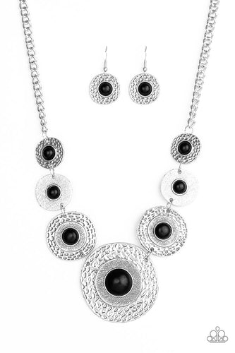 Dotted with smooth black stone centers, mismatched hammered silver frames gradually increase in size as they link below the collar for a fierce look. Features an adjustable clasp closure.