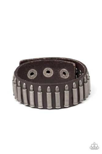 Studded in tin finished bullet frames, a thick brown leather band wraps around the wrist for a rustic look. Features an adjustable snap closure.