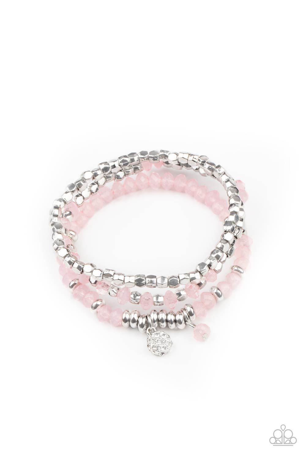 A glimmering collection of silver discs, silver cube beads, and opaque pink crystal-like beads are threaded along stretchy bands around the wrist, creating icy layers. A matching opaque crystal and white rhinestone encrusted charm swing from the display for a whimsical finish.