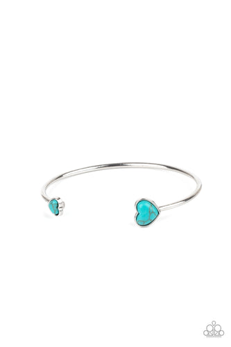 The ends of a dainty silver cuff are dotted with a pair of turquoise stone hearts, adding flirtatious rustic accents to the airy open-faced centerpiece.  Sold as one individual bracelet.